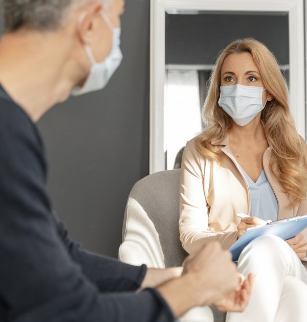 man_with_mask_talking_to_woman_counselor