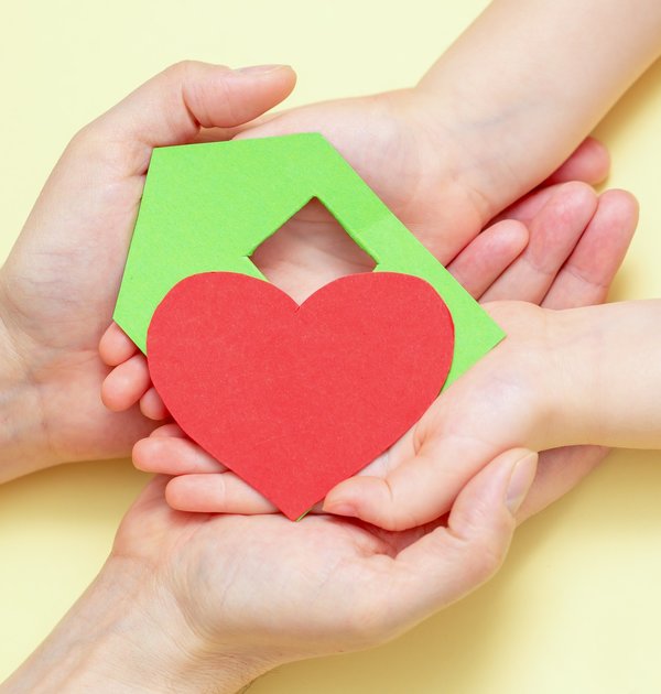 hands_holds_green_paper_house_with_red_heart